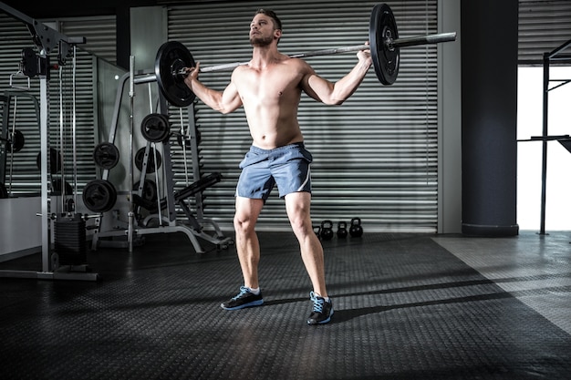 Muskulöser Mann, der einen Barbell anhebt