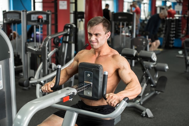 Muskulöser Mann, der im Fitnessstudio trainiert, Übungen, starker Mann