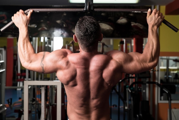 Muskulöser Mann, der im Fitnessstudio trainiert