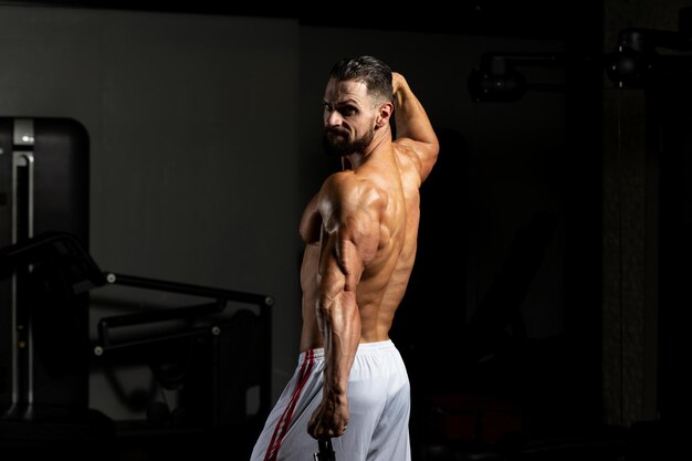 Muskulöser Mann, der sich nach dem Training ausruht und vom Shaker trinkt