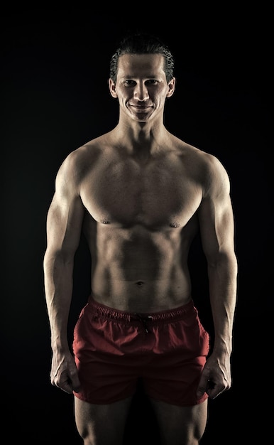 Muskulöser Mann mit starkem Körper Mann, der im Fitnessstudio trainiert, passen Sie Ihren Körper an und verlieren Sie Gewicht Sport und Fitness Athlet oder Sportler in roten Shorts Athlet, der sich vor dem Training aufwärmt Der Fitness gewidmet