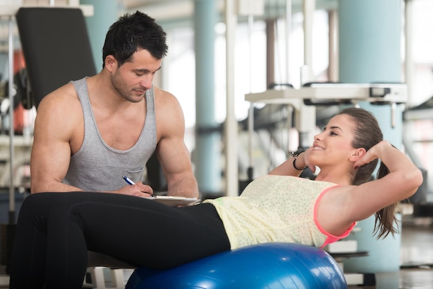 Muskulöser Mann ruht sich nach Übungen aus Porträt eines körperlich fitten jungen Mannes im Fitnessstudio