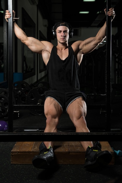 Muskulöser Mann ruht sich nach Übungen aus Porträt eines körperlich fitten jungen Mannes im Fitnessstudio