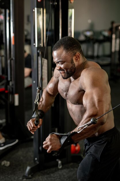 Muskulöser Mann trainiert seine Arme im Fitnessstudio