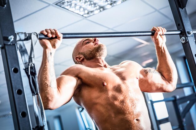 Muskulöser, starker Mann trainiert in einem Fitnessstudio Crossfit-Chinup-Training Bodybuilding und Fettverbrennung