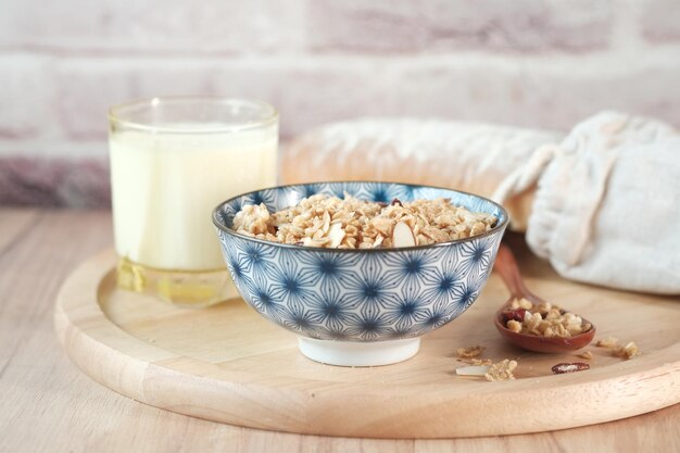 Musli hecho en casa en un tazón vaso de leche y pan en la mesa