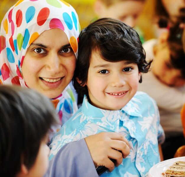 Muslimische arabische Mutter mit Kindern, die Spaß an der Geburtstagsfeier haben