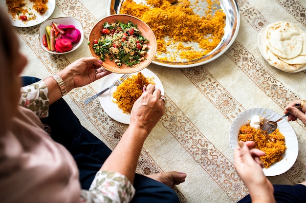 Muslimische familie beim abendessen auf dem boden