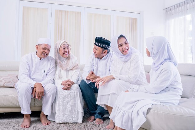 Muslimische Familie der drei Generationen, die zu Hause plaudert