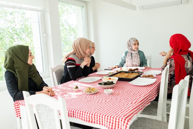 Muslimische Familie und Freunde treffen sich zu Hause zum Abendessen. Foto in hoher Qualität