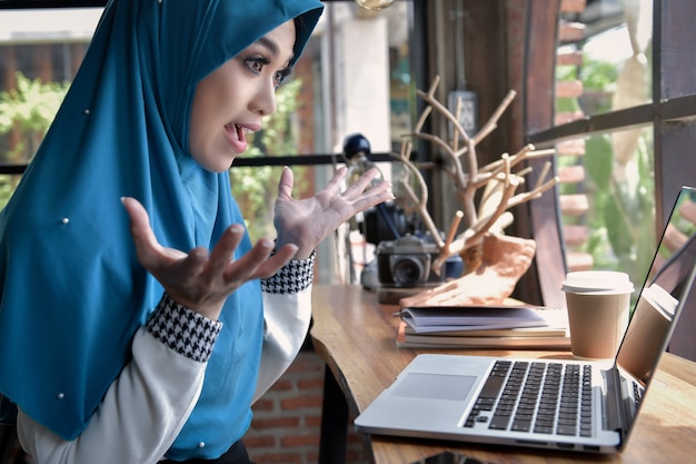 Muslimische frau bespricht geschäft im chat über tablet in ihrem heimbüro, geschäftsidee