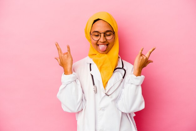Muslimische Frau des jungen Doktors auf Rosa, die Felsengeste mit den Fingern zeigt