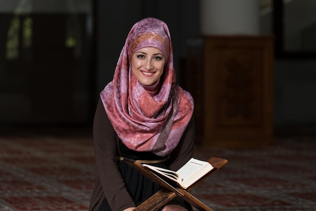 Muslimische Frau, die das heilige islamische Buch Koran liest