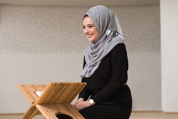 Muslimische frau, die das heilige islamische buch quran liest