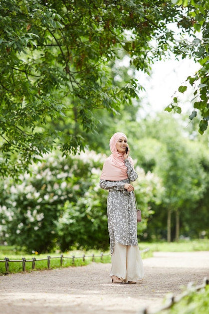 Muslimische Frau, die im Park geht