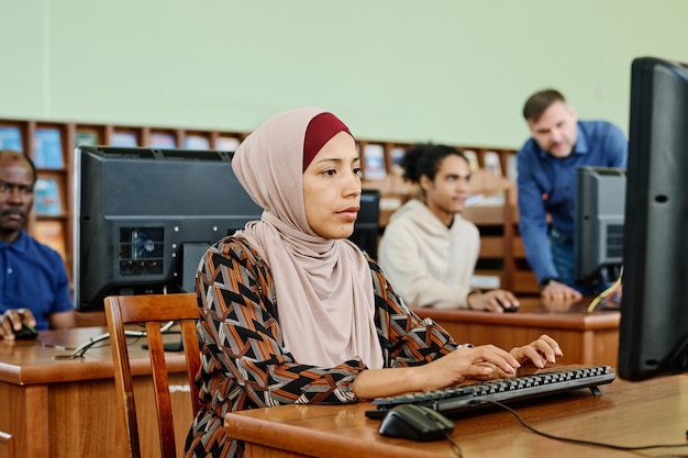 Muslimische Frau, die in der Bibliothek studiert