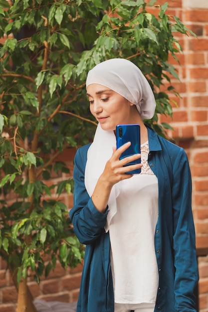 Muslimische Frau, die selfie macht, glückliches schönes Mädchen mit Schal, fotografieren Sie sich selbst mit dem Smartphone