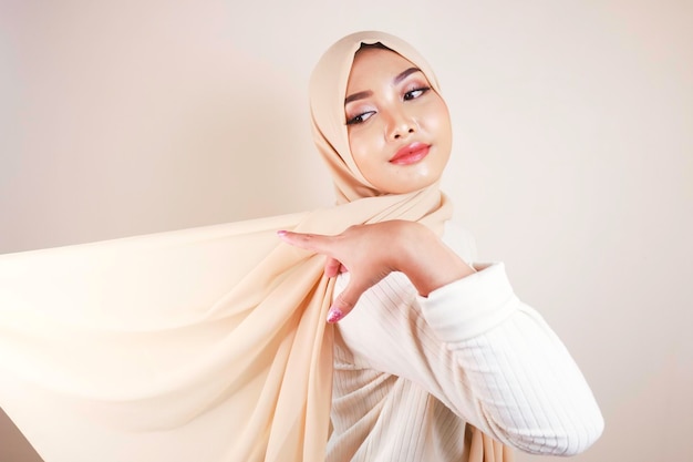 Muslimische Frau, die traditionelle Kleidung und Hijab trägt, isoliert auf weißem Hintergrund Hijab ist ein kreatives fliegendes Idul Fitri- und Hijab-Modekonzept