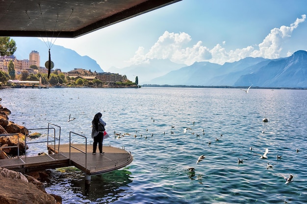 Muslimische Frau steht am Pier im Genfer See in Montreux, Kanton Waadt, Schweiz