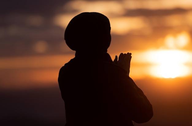 Muslimische Frauen beten mit Anbetung und beten mit offenen Händen und tun bei Sonnenuntergang Dua zu Allah