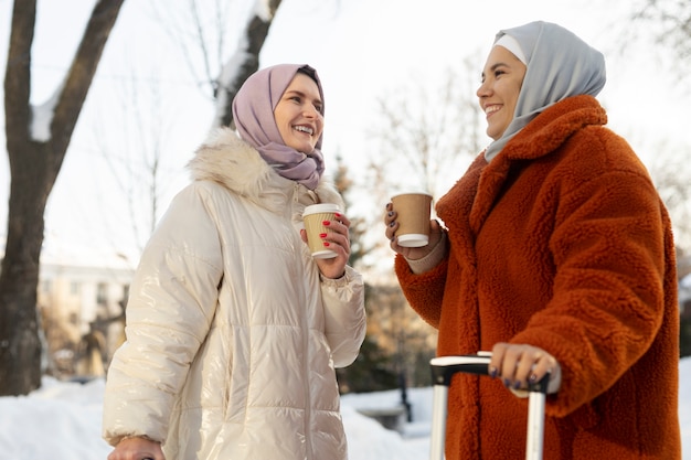 Muslimische Frauen trinken Kaffee und erkunden die Stadt im Urlaub