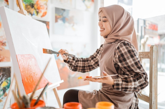 Muslimische Künstlerin malt zu Hause auf Leinwand