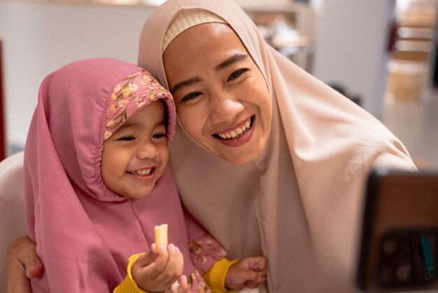 Muslimische Mutter und Kind machen zusammen ein Selfie-Foto