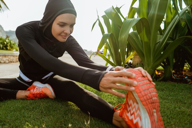 Muslimische Sportfrau streckt ihr Bein