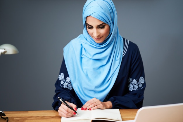 Muslimische Studentin, die in der Bibliothek lernt