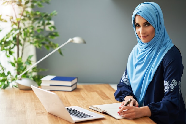 Muslimische Studentin, die in der Bibliothek lernt