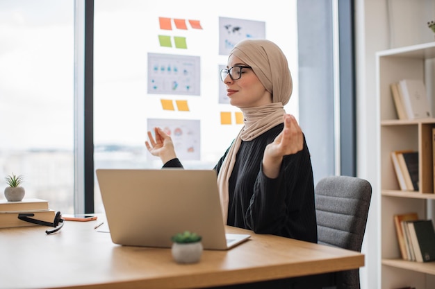 Muslimischer Arbeiter praktiziert Yoga, um Stress im Büro zu lindern