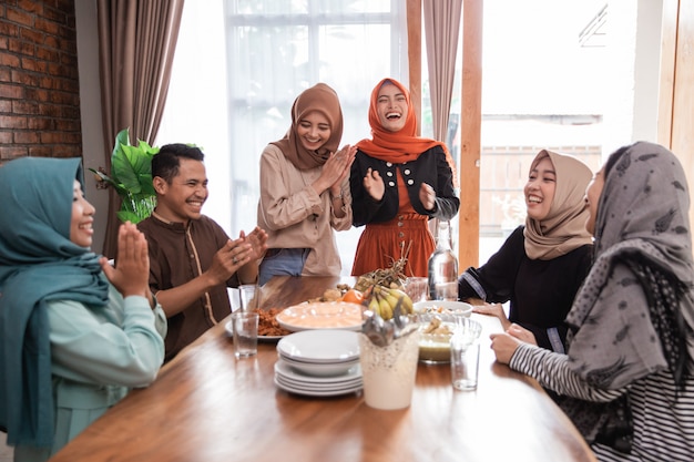 Muslimischer Freund und Familie lachen beim Mittagessen zusammen