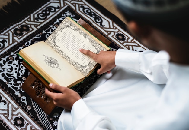 Muslimischer Mann, der den Koran studiert