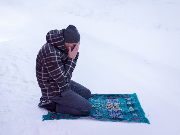 Muslimischer Reisender, der im Winterberg betet