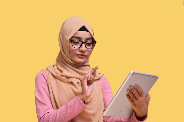 muslimisches mädchen mit hijab mit brille mit tab indischem pakistanischem modell