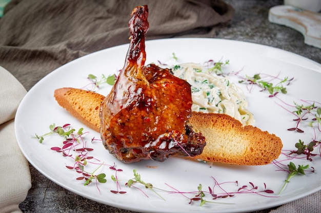 Muslo de conejo asado ahumado Acompañado de mousse Pan crujiente de tres quesos con calabacín asado a las finas hierbas