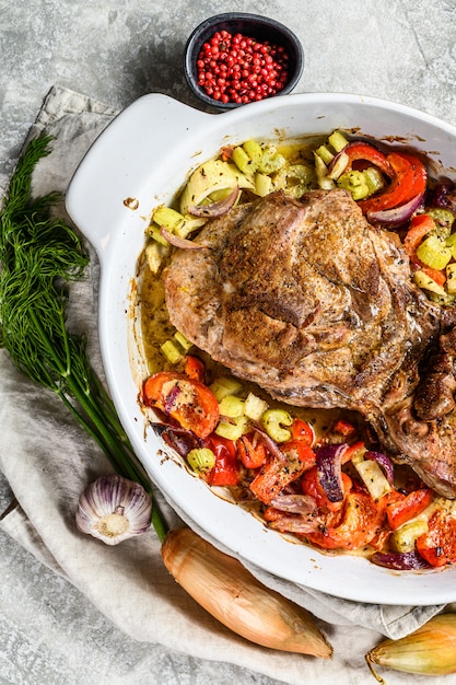 Muslo de pavo al horno con verduras en una fuente para horno.