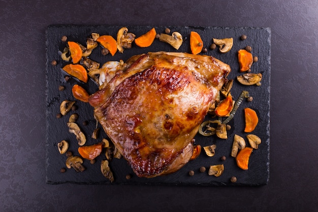 Foto el muslo pavo coció en el horno con las especias en fondo de piedra negro. comida sana. cena de acción de gracias.