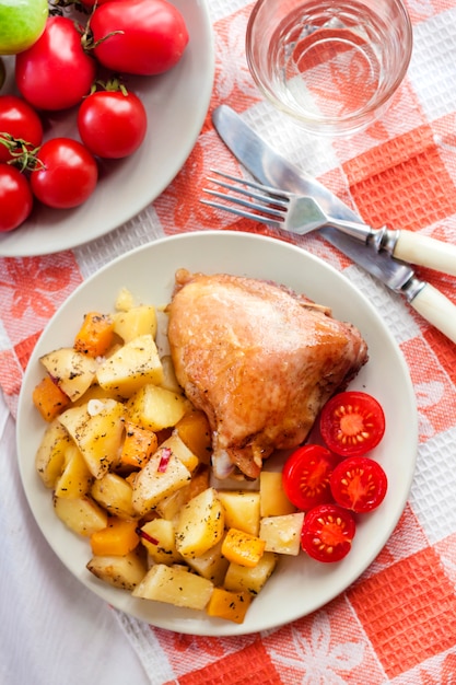 Foto muslo de pollo al horno con papas al horno y guarnición de calabaza