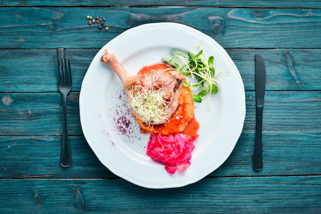 Muslo de pollo al horno con puré de calabaza. en el plato Vista superior. Espacio libre para su texto. Estilo rústico.