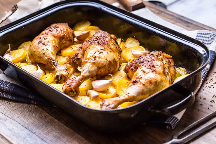Muslo de pollo asado con patatas con alcaravea y ajo.