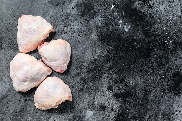 Muslo de pollo fresco, carne de aves de corral orgánica. Fondo negro.