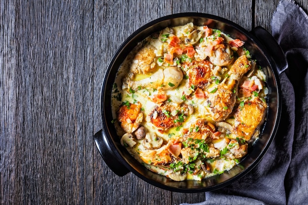 Muslos y muslos de pollo en salsa de crema de vino blanco con mostaza y especias, vino blanco Coq au Vin, estofado de pollo, vista horizontal desde arriba, plano, espacio libre