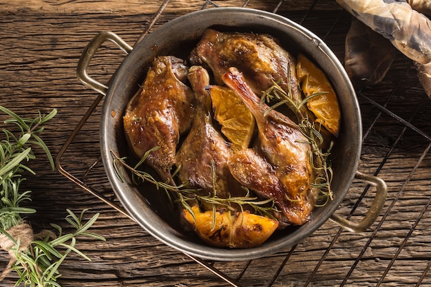 Muslos de pato asado en sartén con naranjas hierbas col lombarda y pankaces de patata.