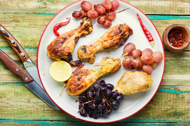 Muslos de pollo al horno con uvas sobre mesa de madera rústica