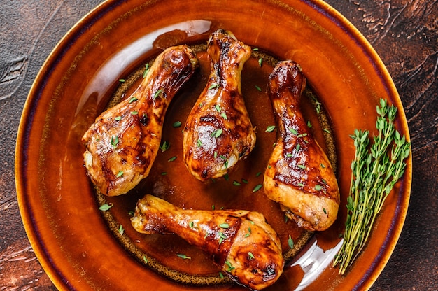 Muslos de pollo a la barbacoa calientes y picantes en un plato. Fondo oscuro. vista superior.