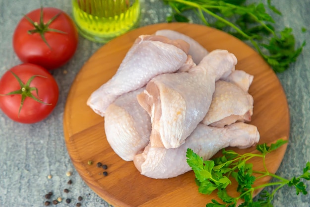 Muslos de pollo de carne cruda en un tablero Enfoque selectivo