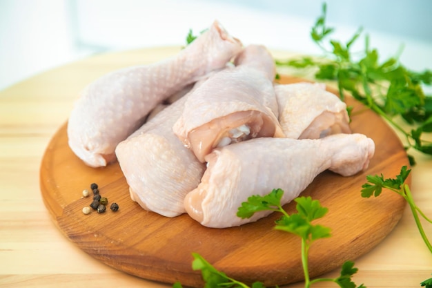 Muslos de pollo de carne cruda en un tablero Enfoque selectivo