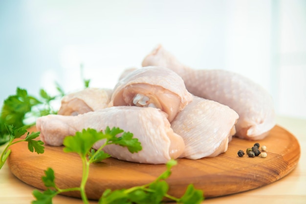 Muslos de pollo de carne cruda en un tablero Enfoque selectivo