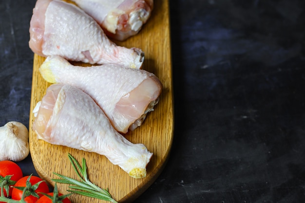 Muslos de pollo crudo carne para cocinar en la mesa